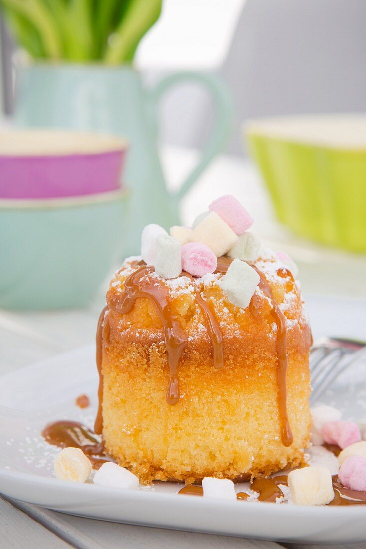 A mini sponge cake with caramel sauce and marshmallows