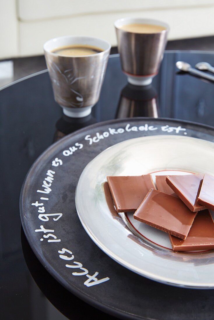Teller mit Schokoladenstücken auf beschriftetem Platzteller