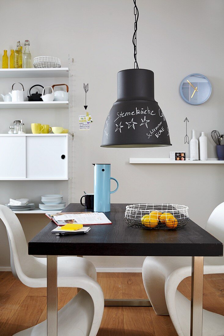 Black and white furniture and writing on chalkboard lamp in dining room