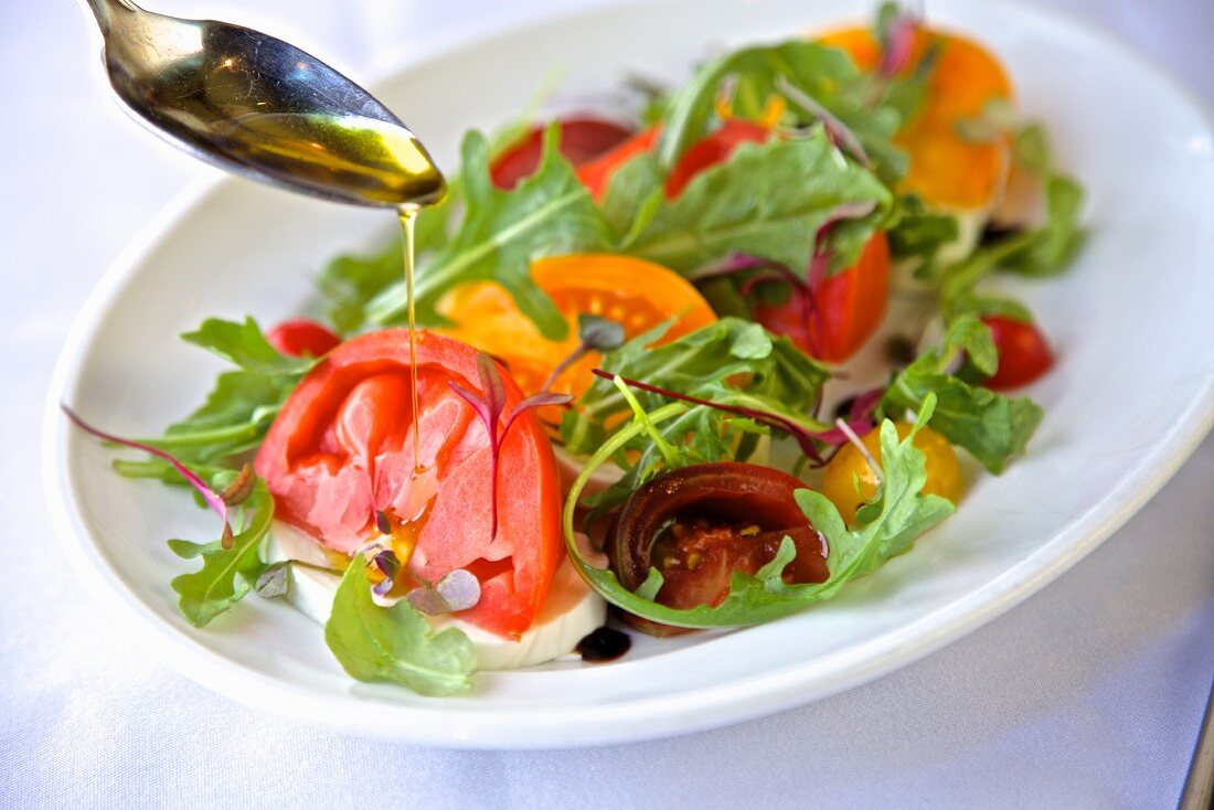 A heirloom tomato salad with rocket, balsamic vinegar and olive oil