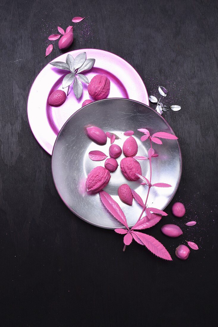 Arrangement of pink nuts and leaves on plates