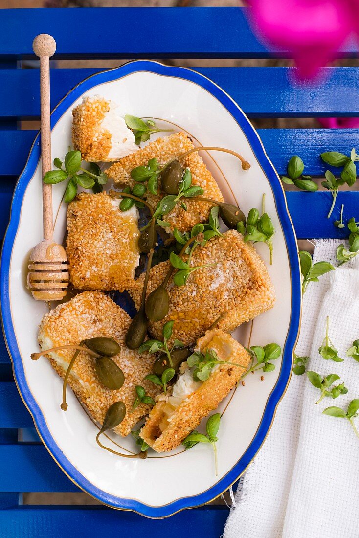 Gebratener Feta in der Sesamkruste mit Honig, Kapernäpfel und Basilikum