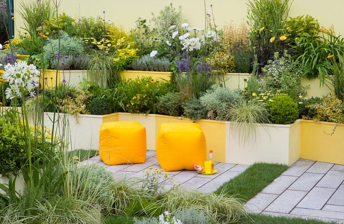 Terraced beds in shades of yellow in courtyard garden