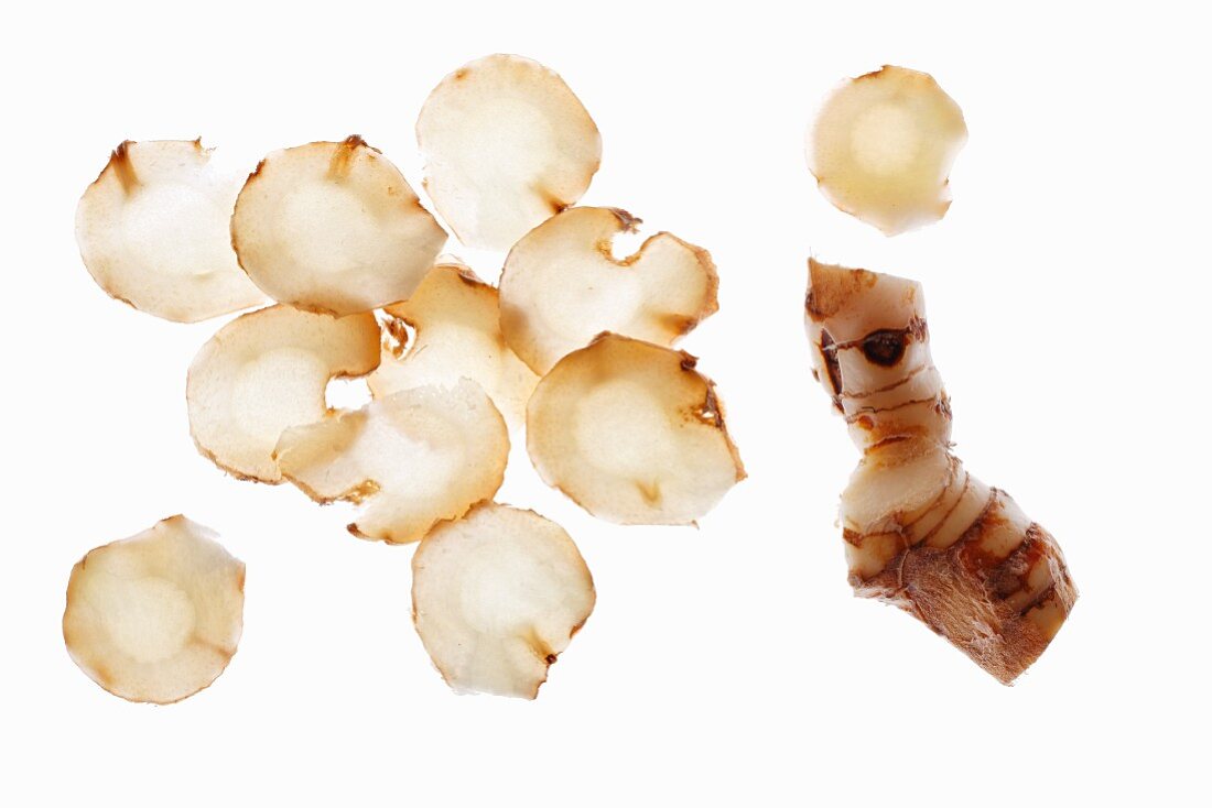 Sliced galangal on a white surface
