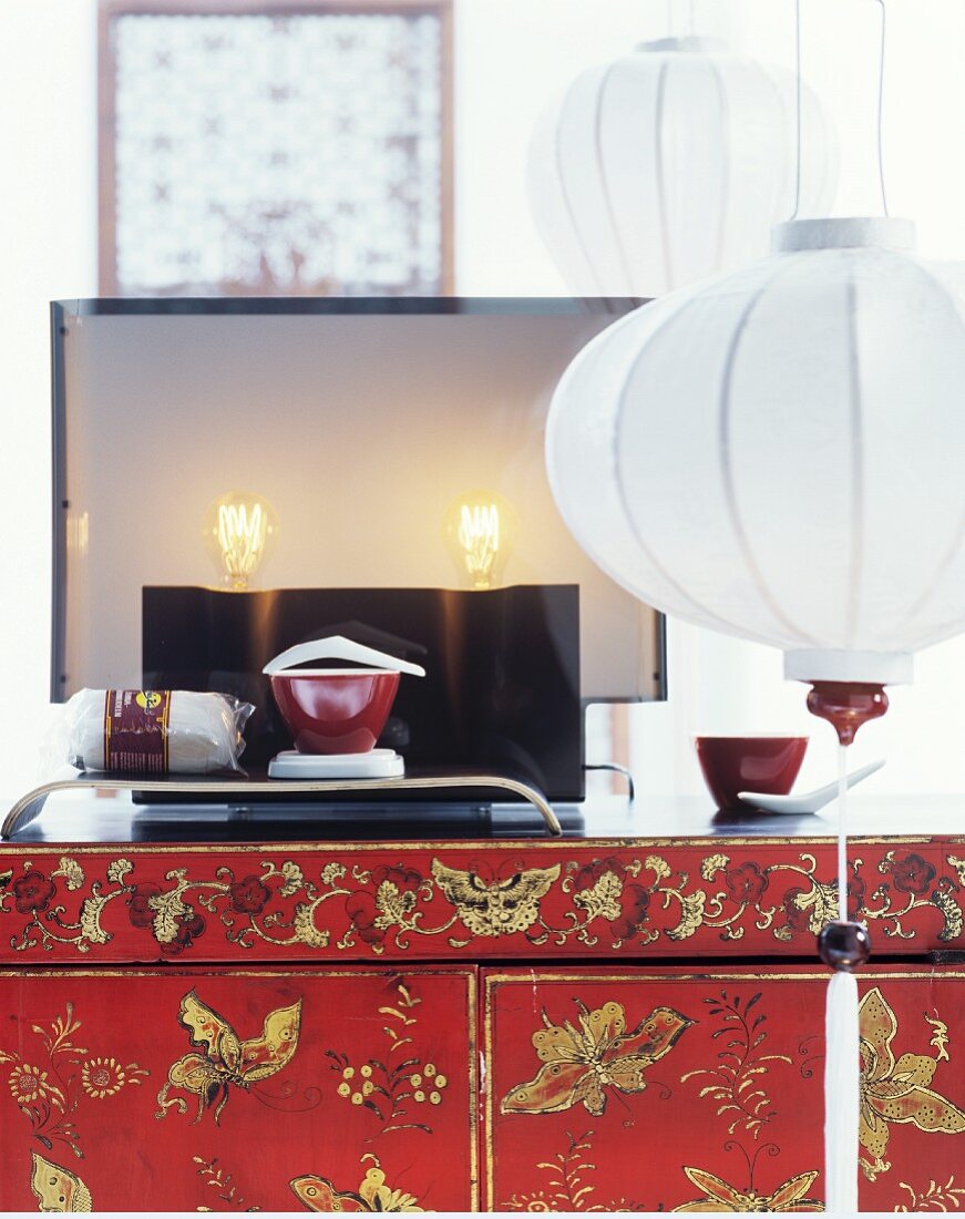 Modern table lamp on lacquered cabinet; white lanterns