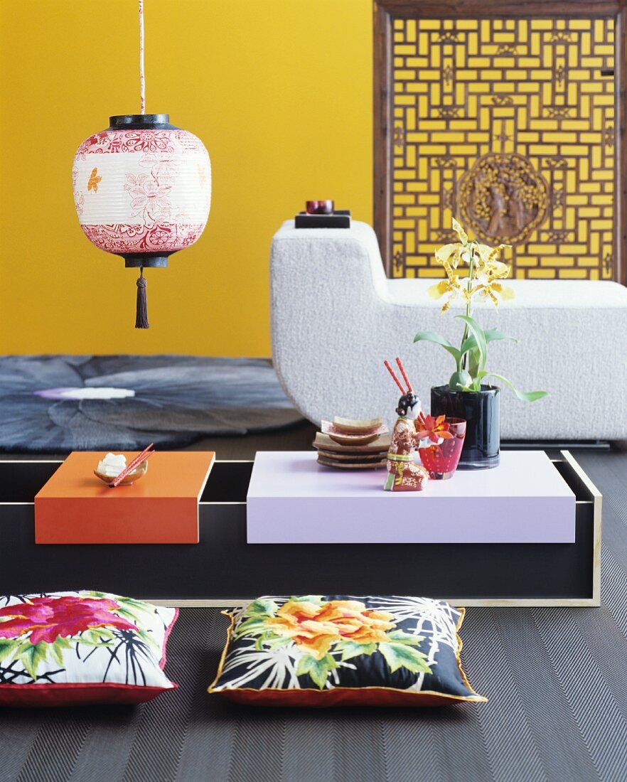 Low Oriental table, floor cushions, modern lounger and yellow wall