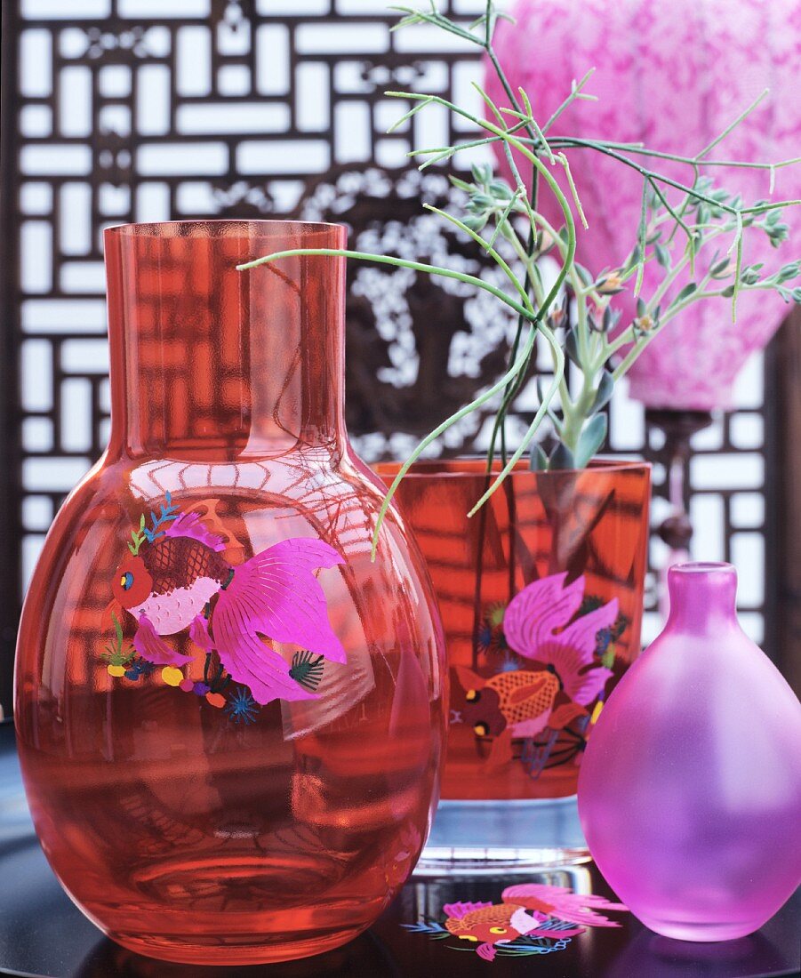Red glass vases with fish motifs and pink vase