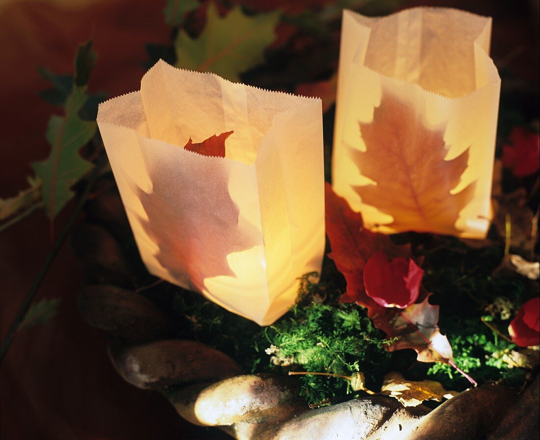Mit Herbstlaub dekorierte Windlichter aus Papiertüten