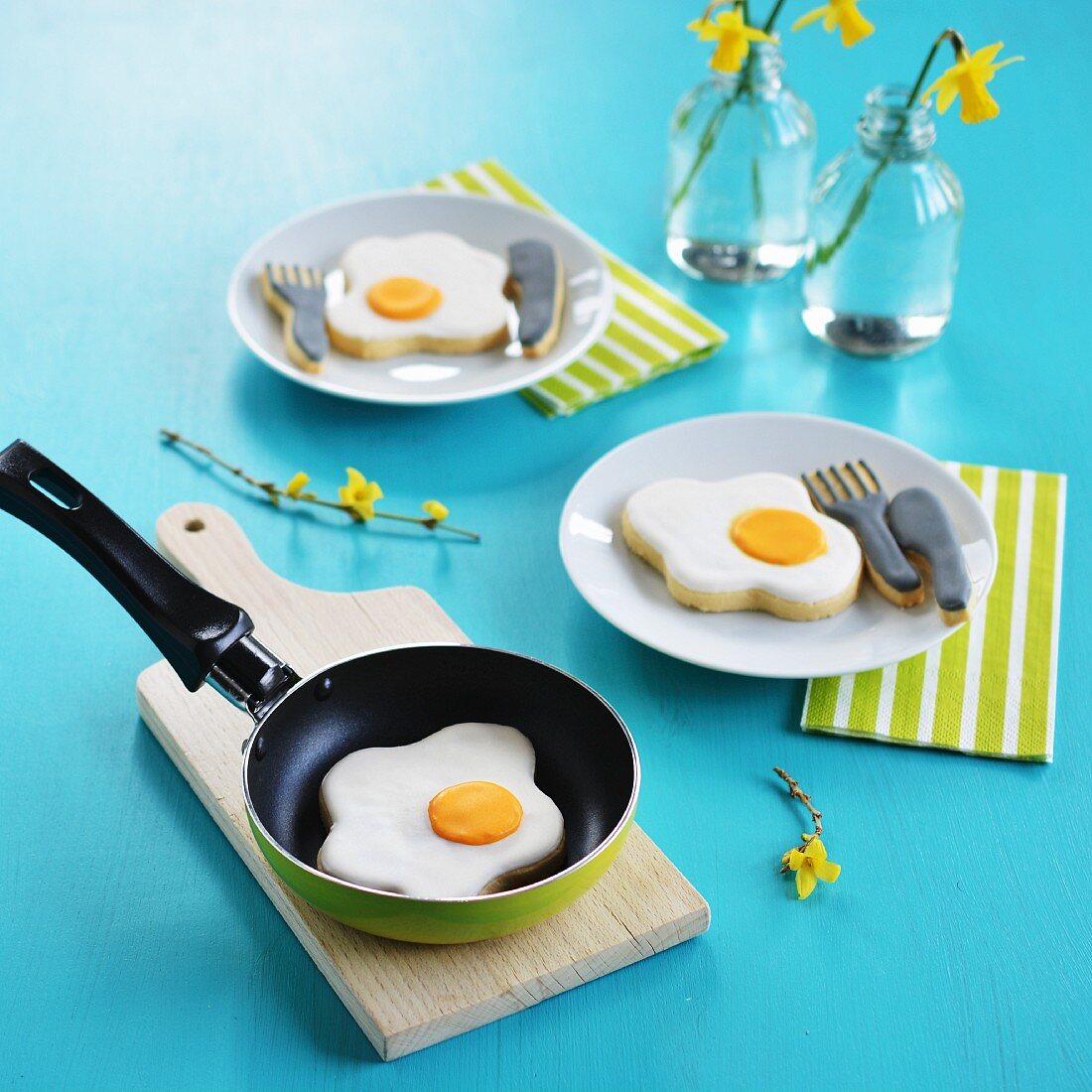Fried egg and cutlery-shaped biscuits in a pan and on plates