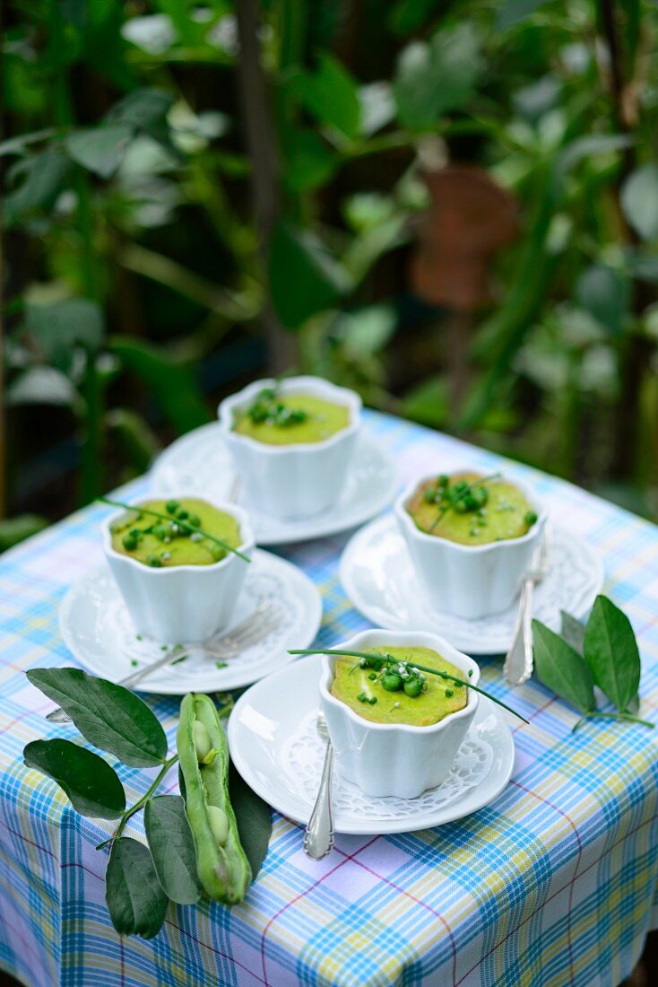 Pea flans with broad beans and chives on a table outside