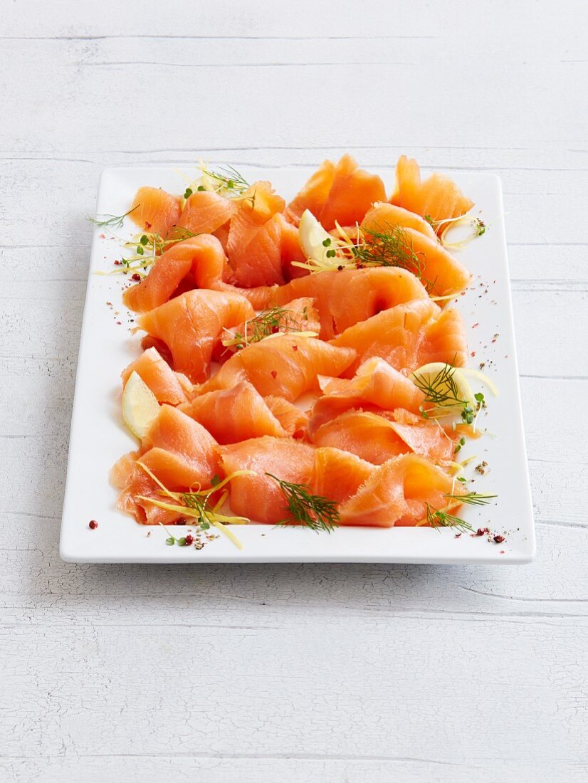 Smoked salmon with dill and lemon on a serving platter
