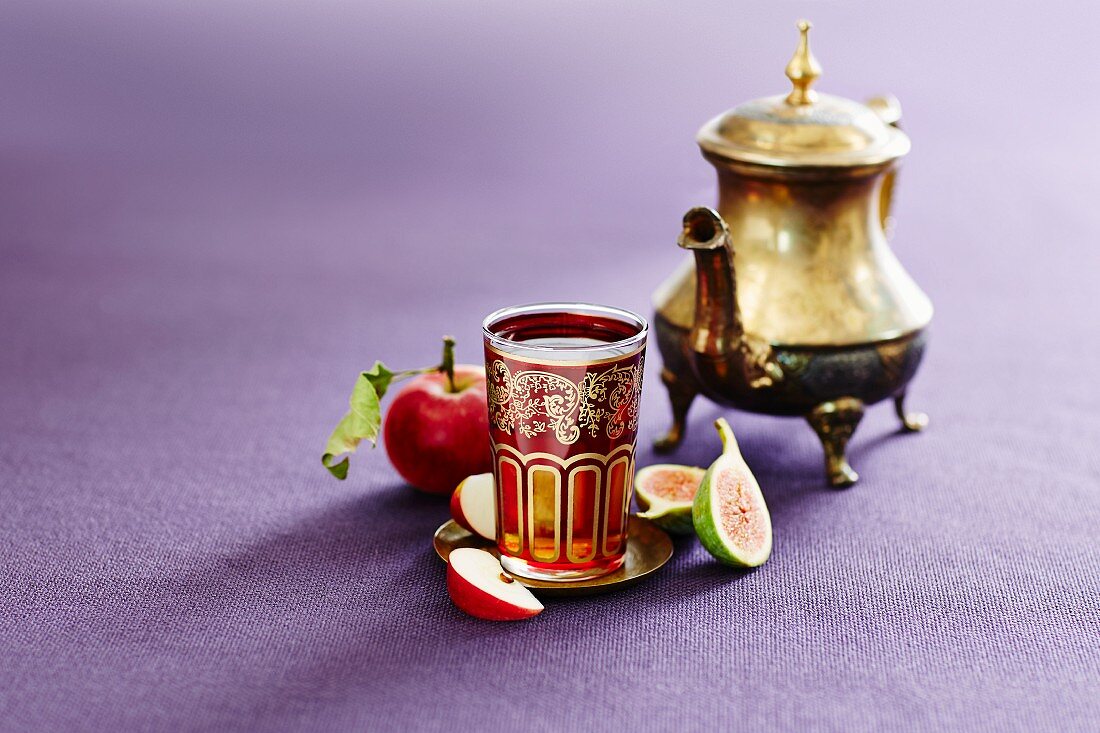 A silver teapot and a glass of Turkish apple tea