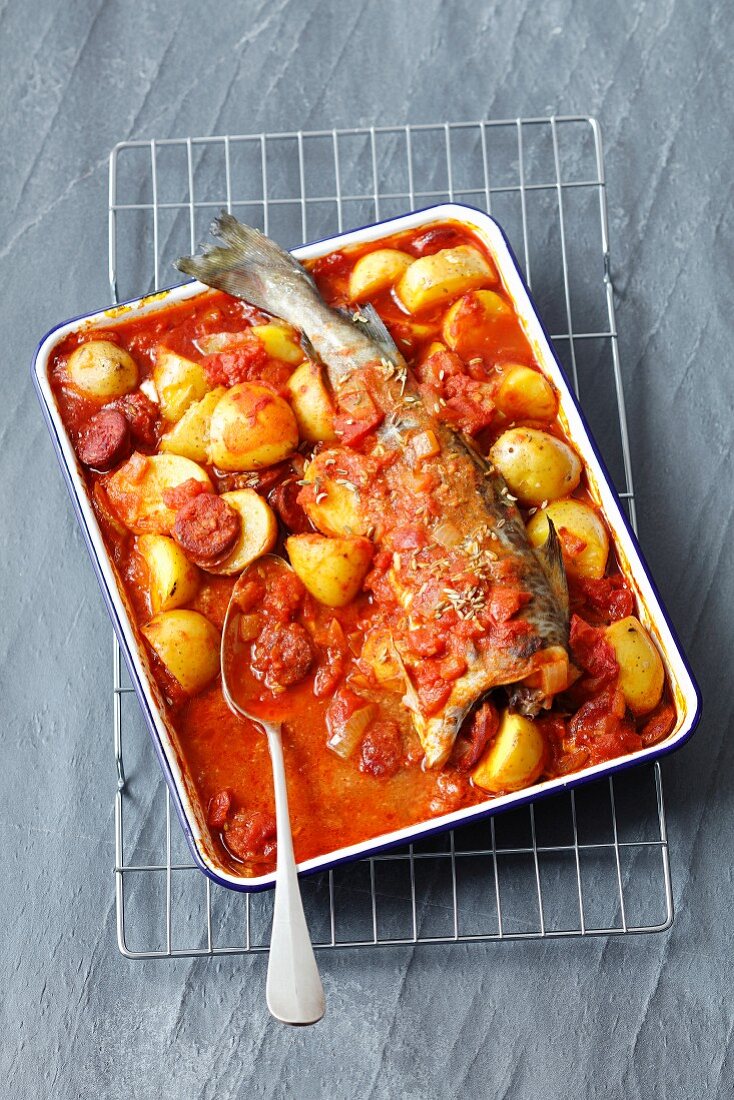 Oven-baked cod with potatoes, chorizo and tomato sauce