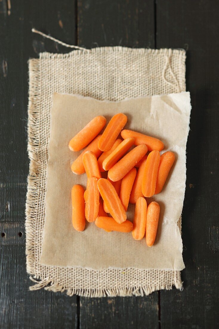 Small, halved carrots on a piece of paper