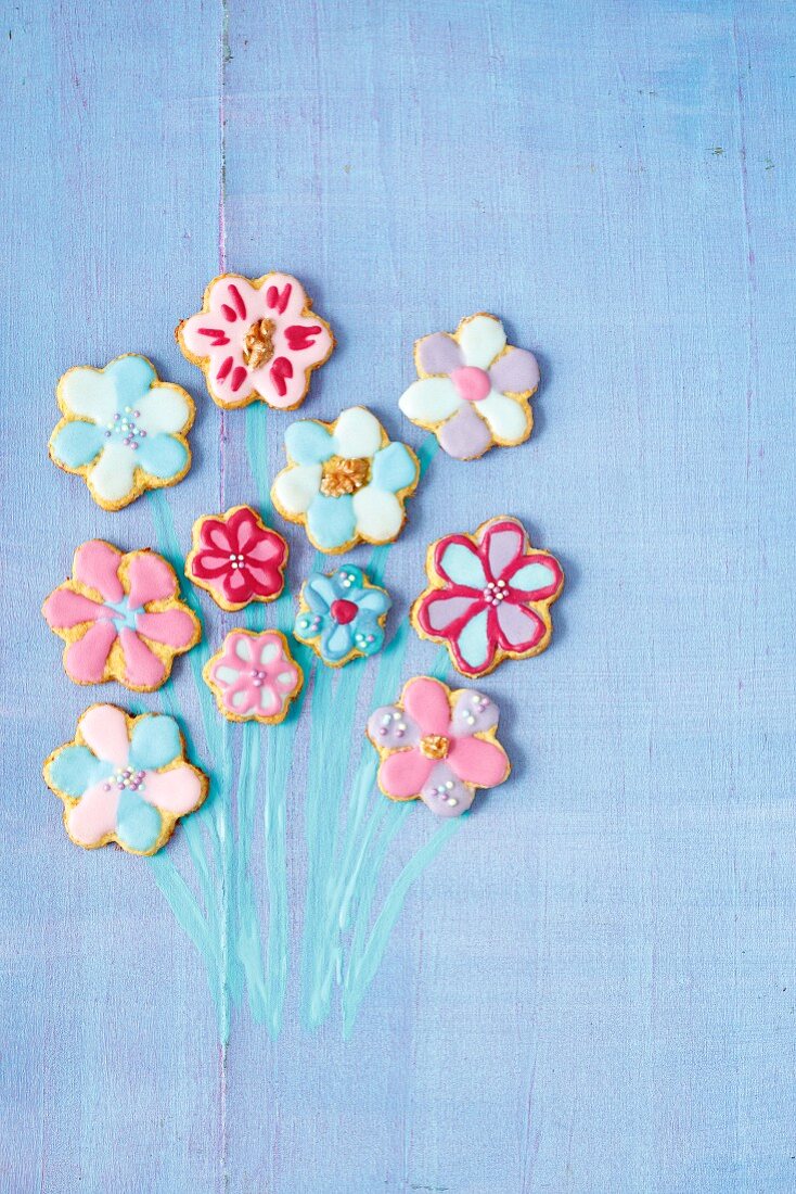 Flower-shaped carrot cookies with colourful sugar glaze