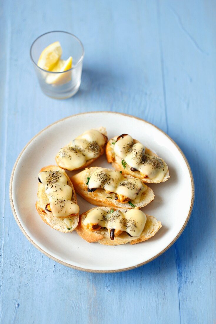 Toasted baguette slices topped with mussels and cheese