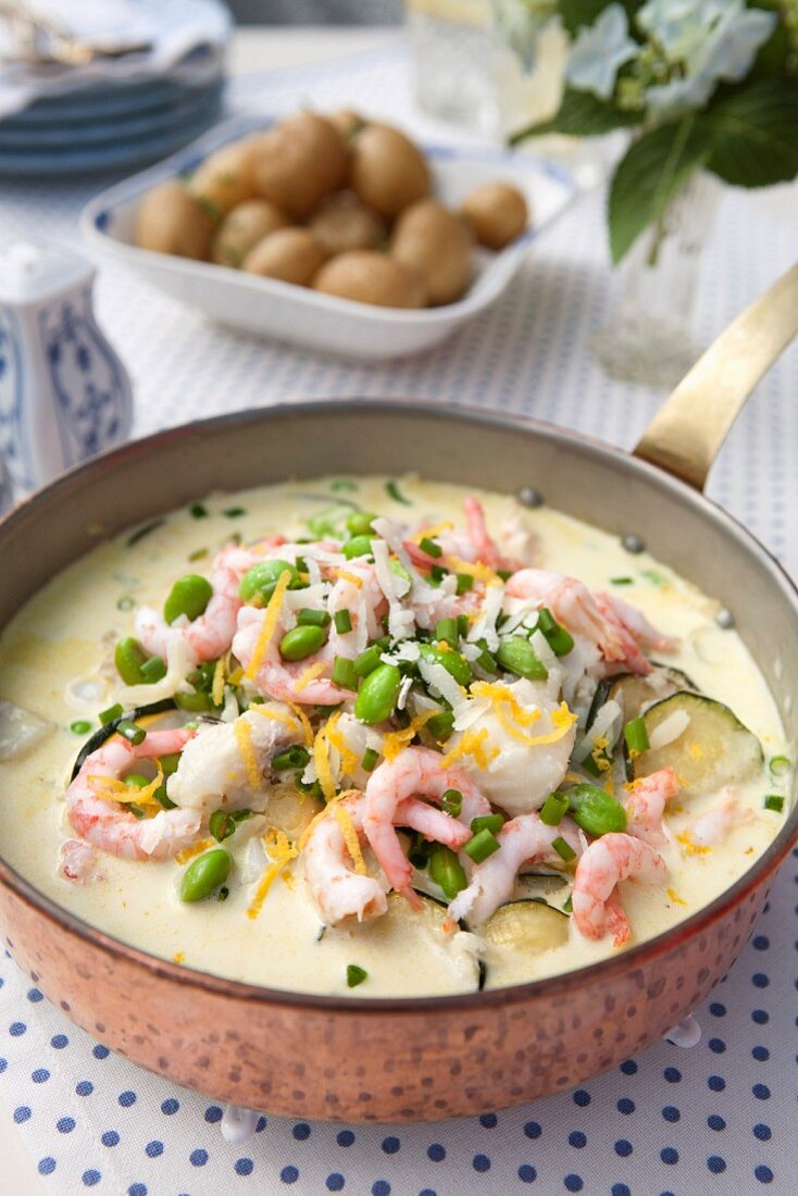 Fish stew with prawns, soya beans, courgette and chives