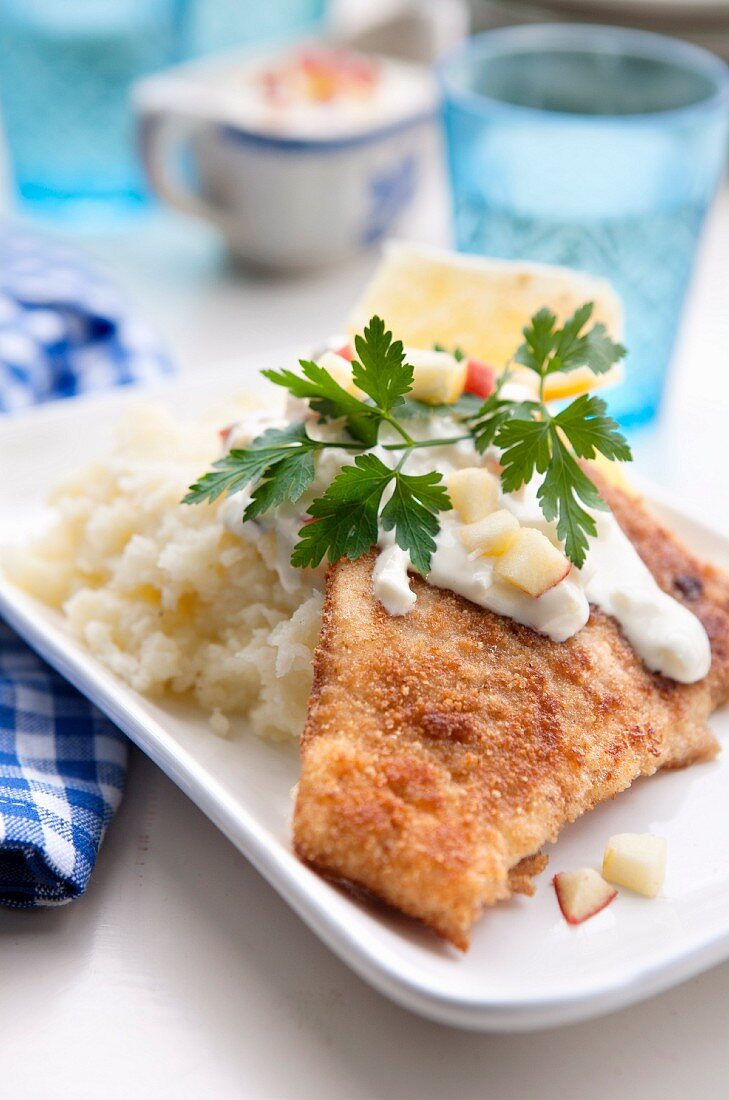 Breaded plaice with mashed potatoes, a light sauce and diced apples
