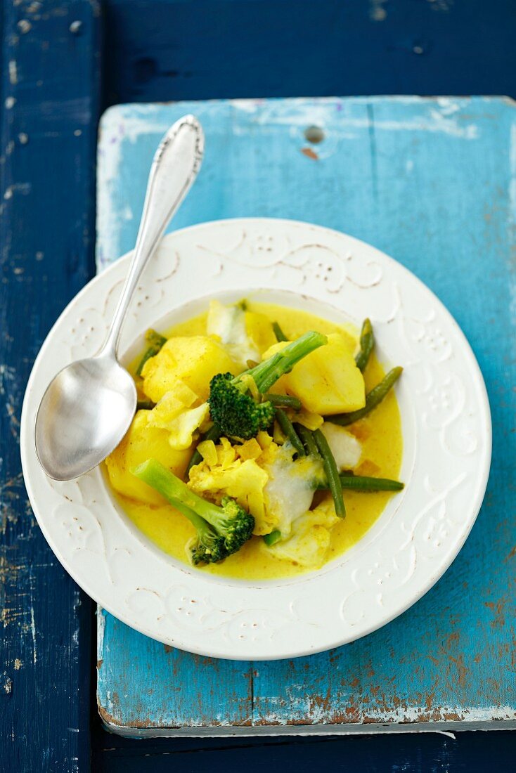 Vegetarian curry with potatoes, beans, cauliflower, onions and broccoli