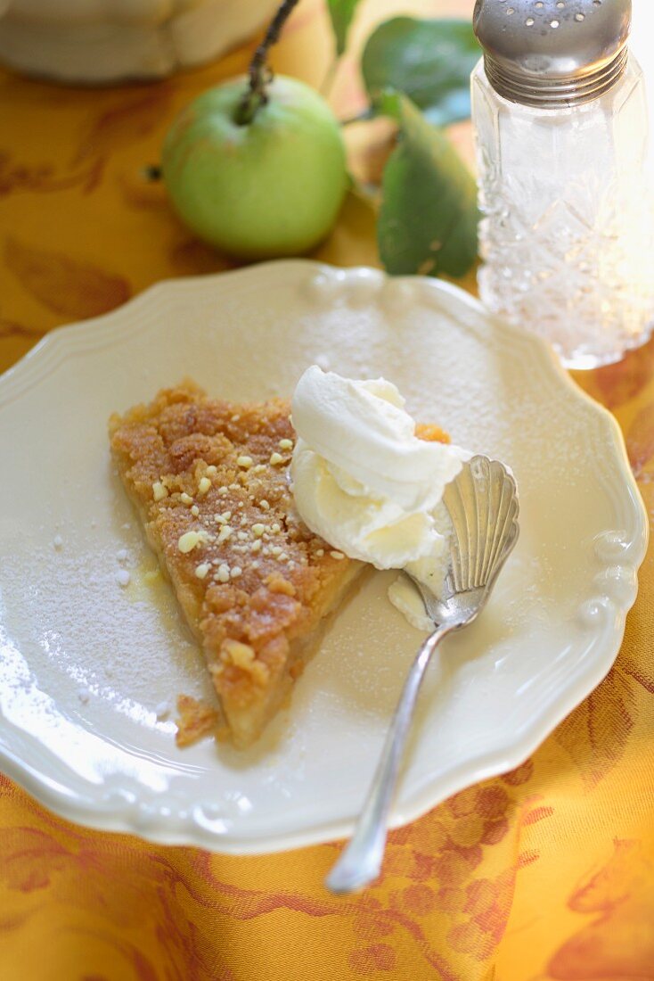 Ein Stück Tarte Tatin mit Sahne auf Teller