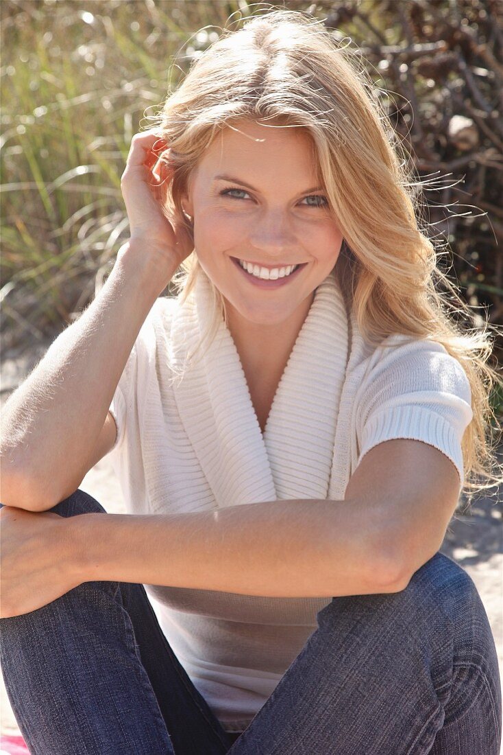 Young blonde woman wearing jeans and knitted top