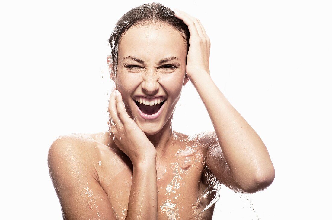 Topless woman under running shower