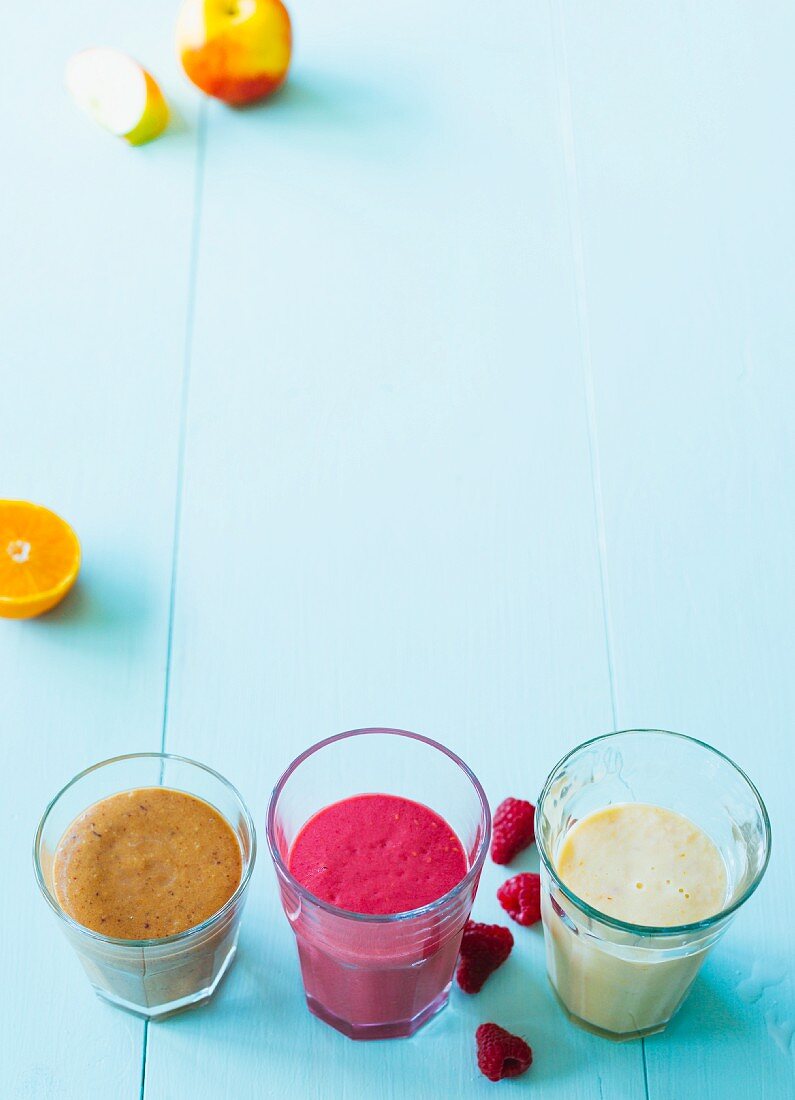 Three smoothies with almond mousse, plums, oranges and banana (Paleo)