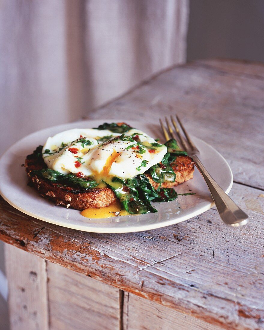 A poached egg with spinach on toast