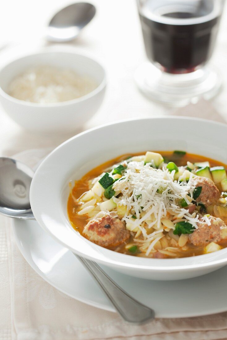 Orzo soup with meatballs, courgette and Parmesan cheese