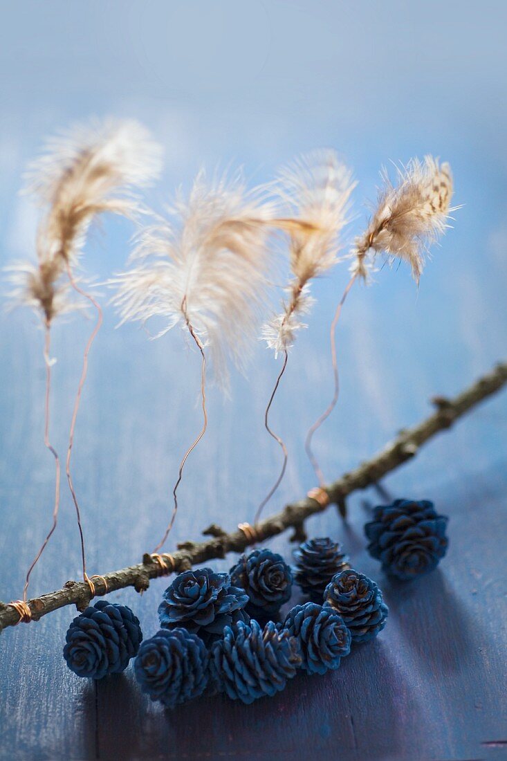 Feathers attached to twig with wire and painted larch cones