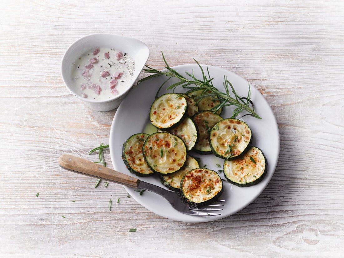 Courgettes slices with rosemary and a ham and cheese sauce