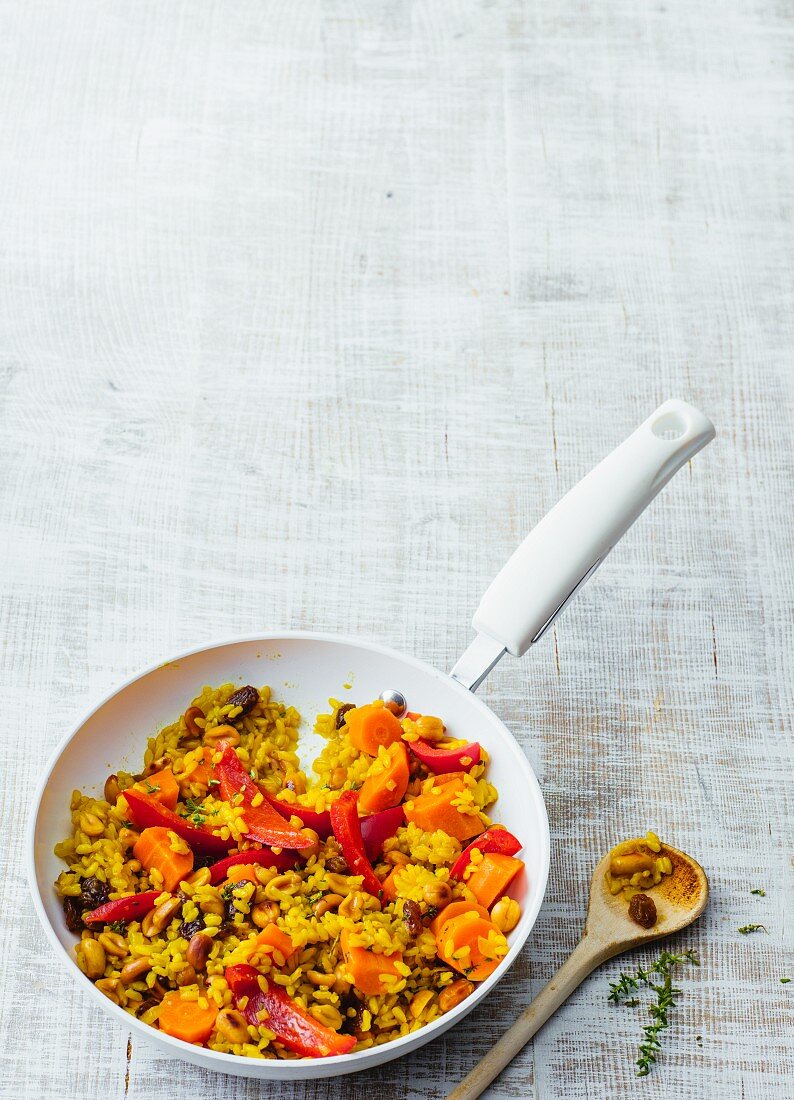 Sweet fried rice and carrot with raisins, honey and peanuts