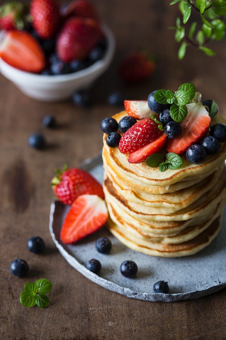 Gestapelte Pancakes mit frischen Erdbeeren und Heidelbeeren (USA)