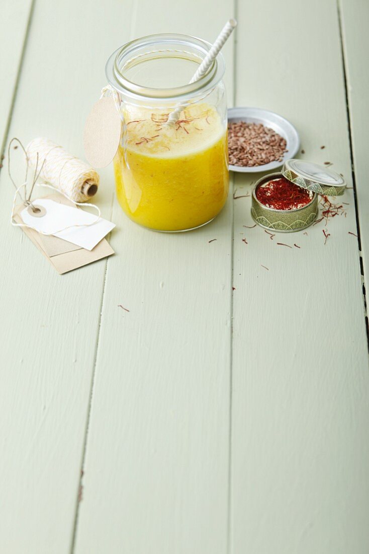 An orange and pineapple smoothie with saffron and flaxseeds