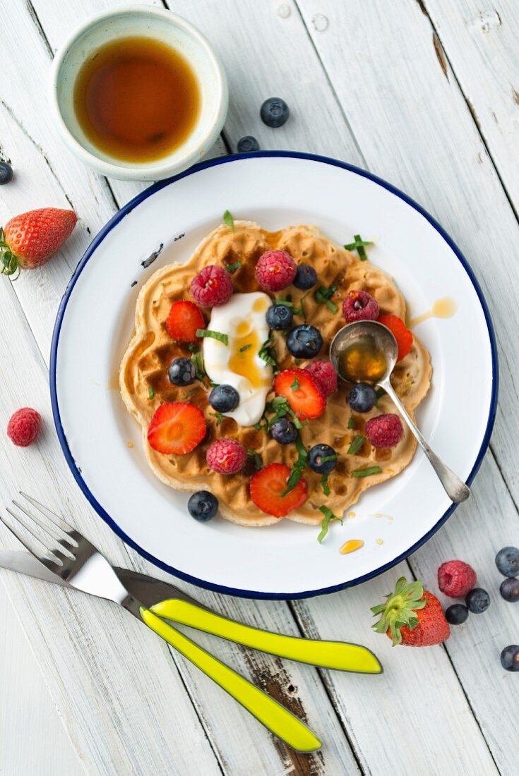 A vegan, gluten-free waffle with fresh berries and yoghurt