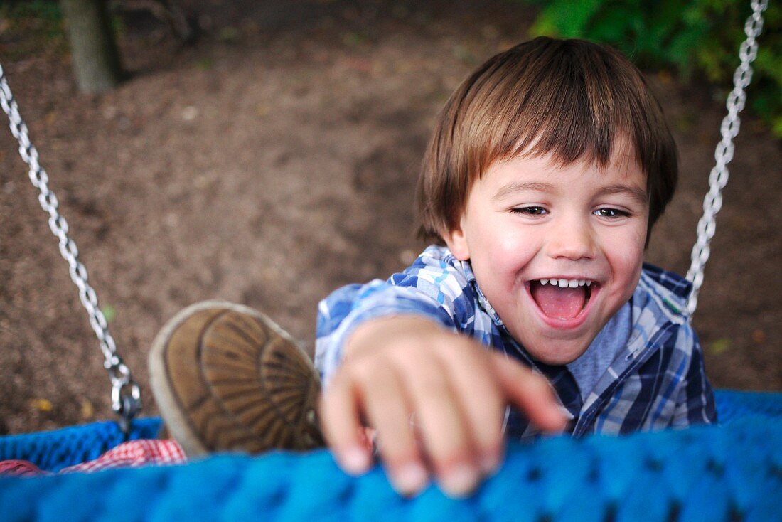 A little boy outside on a climbing frame