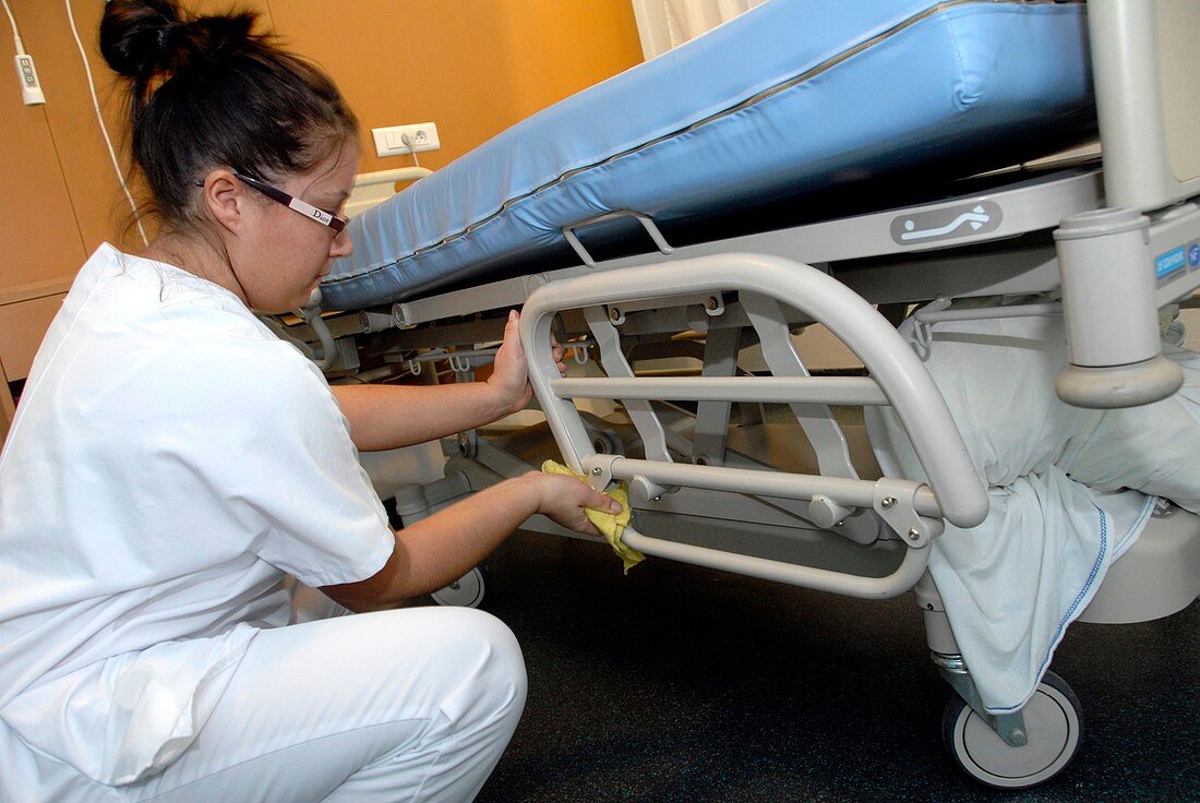 Nurse cleaning hospital bed