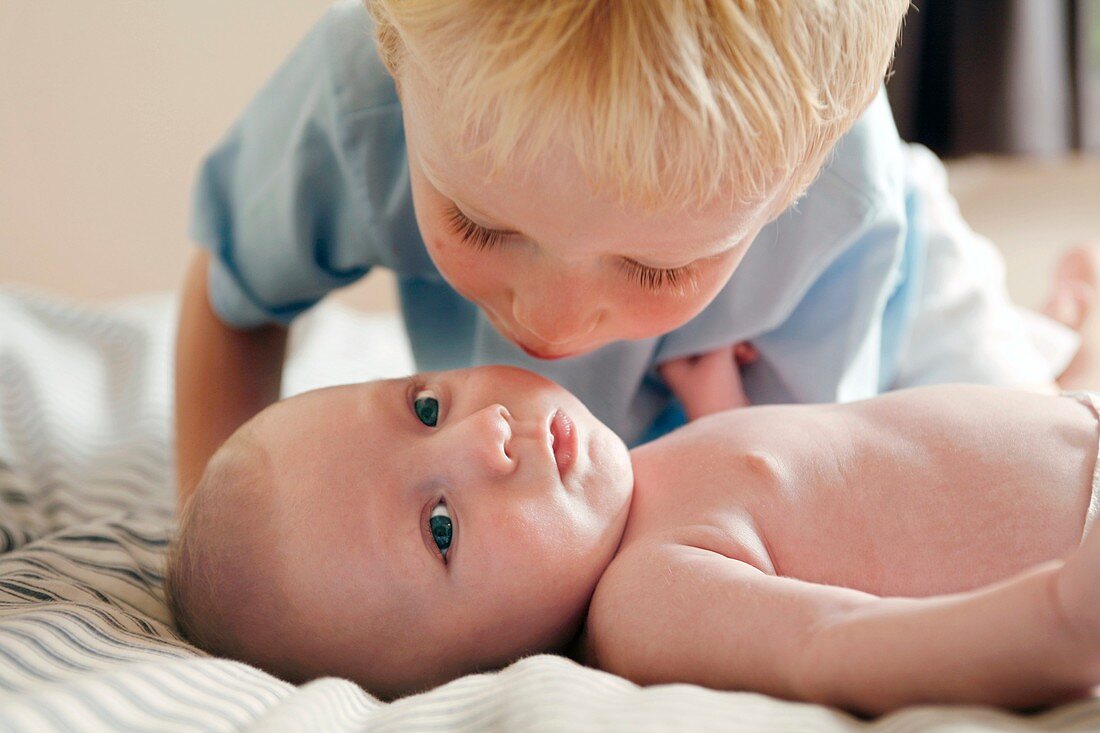 Boy kissing his baby brother