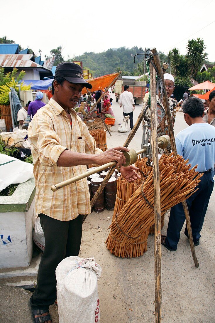 Person selling cinnamon stick at market