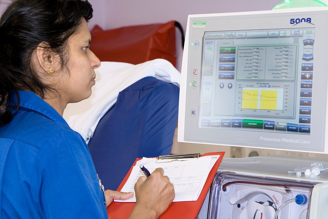 Nurse reads a dialysis machine