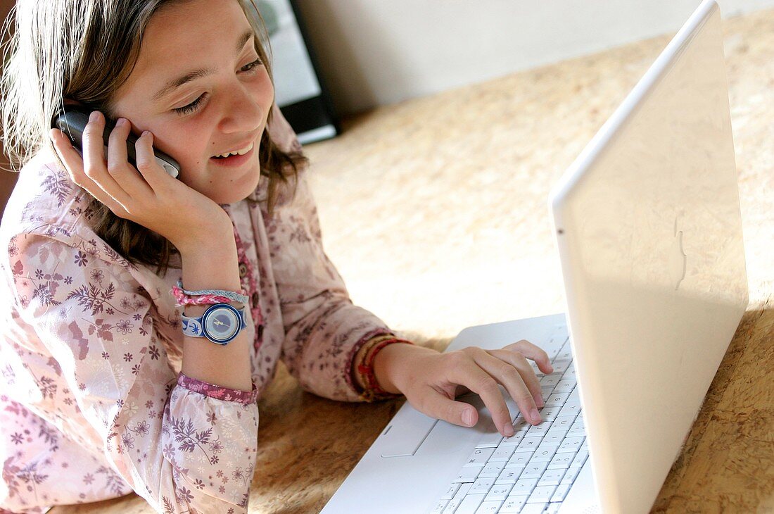 Girl using a laptop and mobile phone