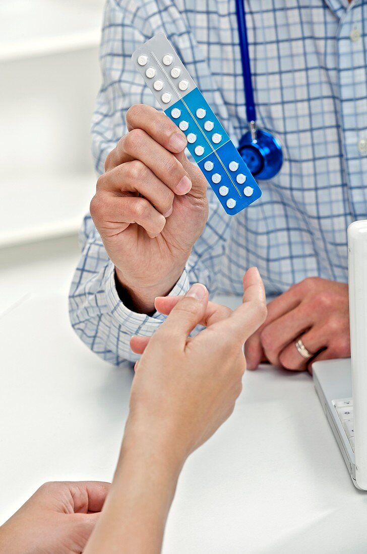 Doctor showing pills to a patient