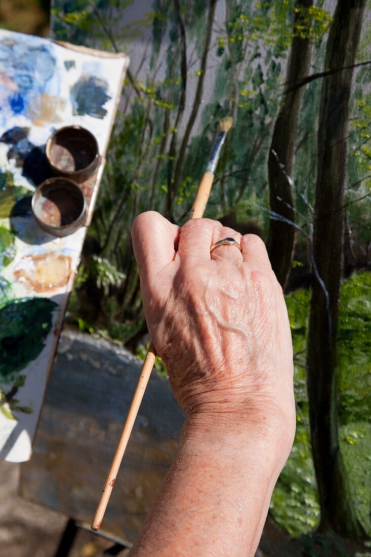Hand of an elderly woman painting