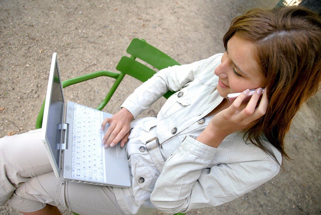 Woman using a laptop and mobile phone