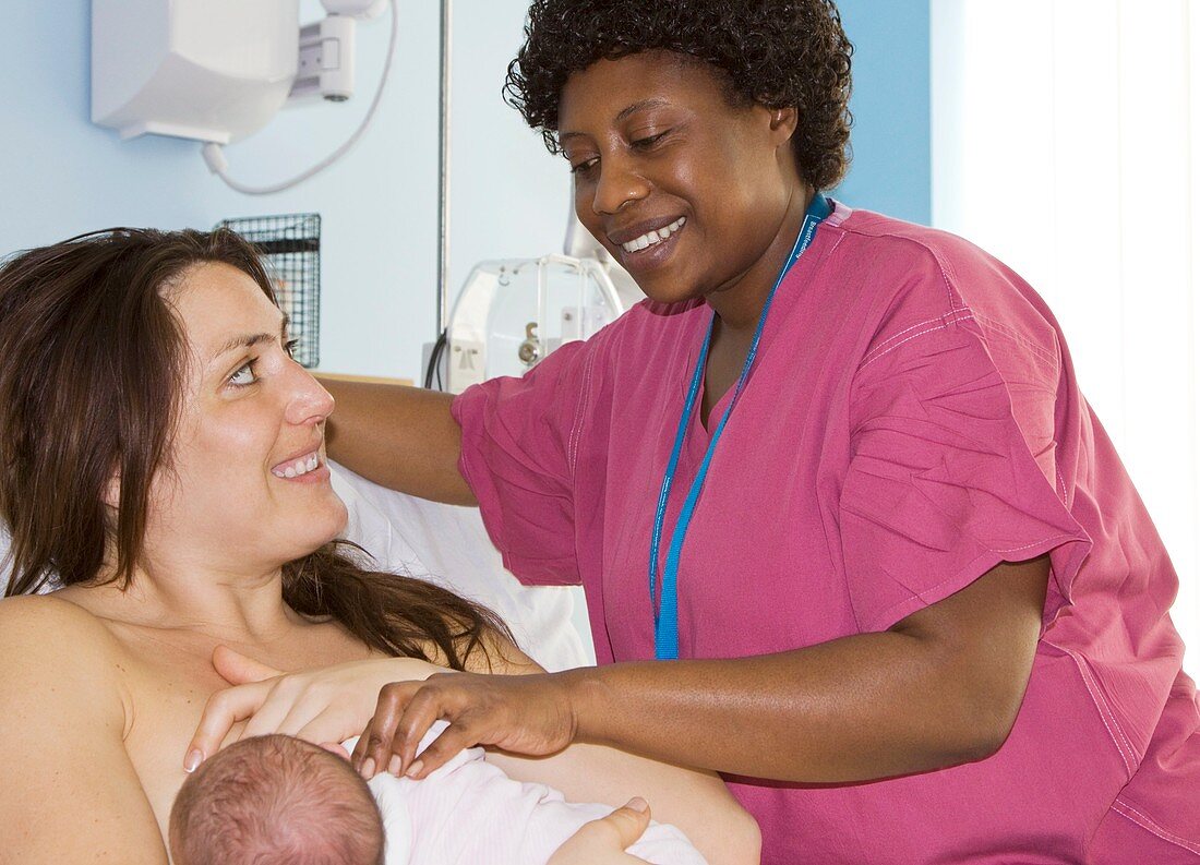 Nurse with mother and newborn baby girl