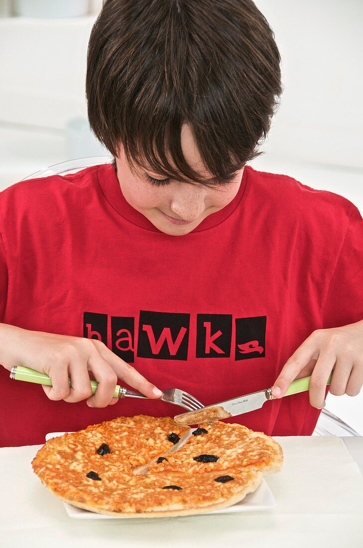 Teenage boy eating pizza