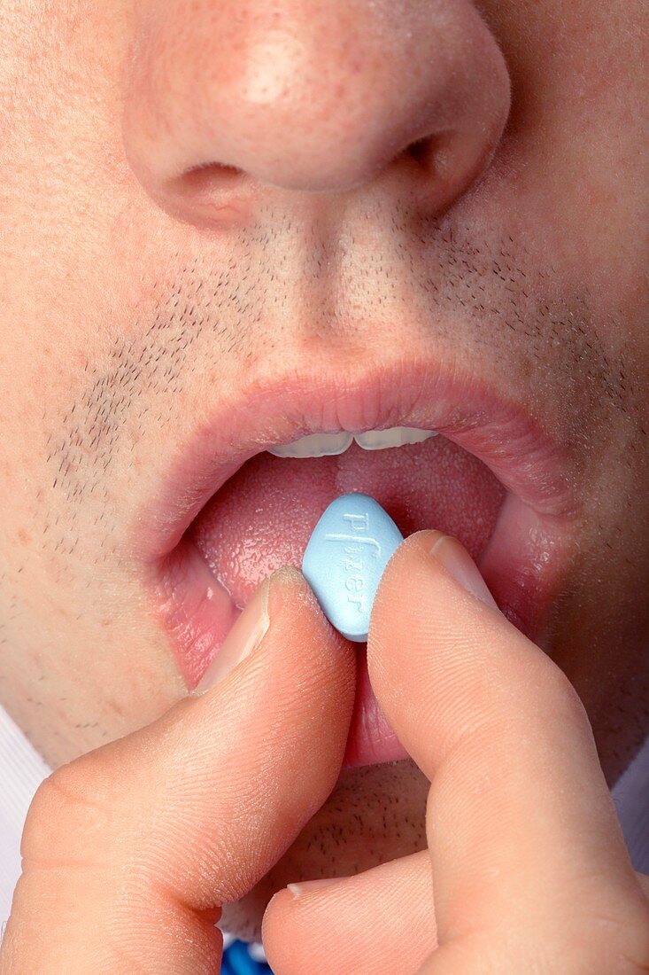 Man taking a viagra tablet