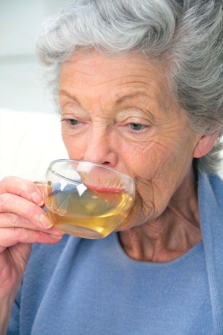 Elderly woman drinking herbal tea