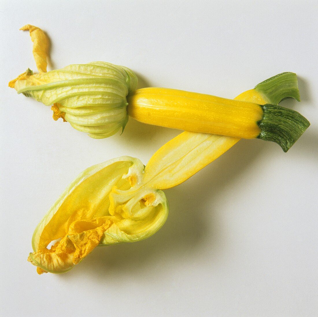 Halbierte gelbe Zucchini mit Blüte