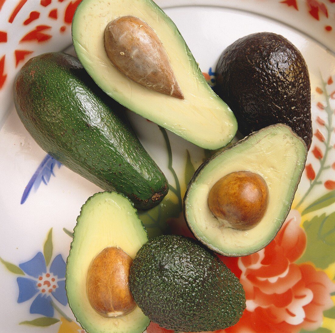 Stillleben mit ganzen und halbierten Avocados